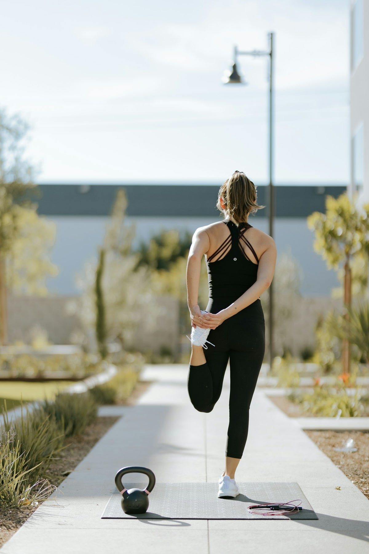 Femme s'étirant après un entraînement en extérieur avec un kettlebell